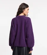 Suéter color violeta en tejido de punto con textura de punto onda, cuello redondo y mangas largas abullonadas.