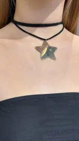 Gargantilla doble de cuero sintético negro con dije de estrella plateada.