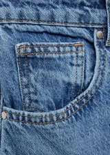 Pantalón de jean azul de corte amplio, tiro medio y cinco bolsillos.