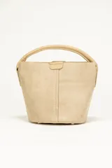 Mini cartera color beige de gamuza, con asa corta y forro interior.