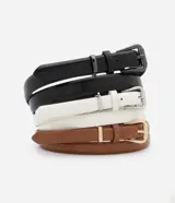 Set de tres cinturones finos de cuero sintético con textura croco, hebilla metálica cuadrada y doble trabilla. Incluye un cinturón negro, uno blanco y uno marrón.