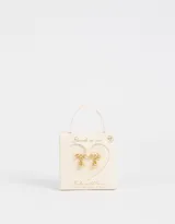 Par de aros pasantes dorados con forma de moño con incrustaciones de strass y dije colgante de corazón liso.