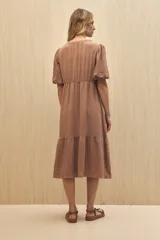 Vestido midi color marrón claro, con escote en V, mangas cortas abullonadas, botones frontales y falda con volantes.