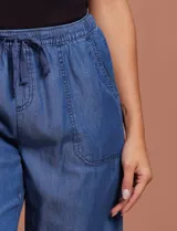 Pantalón capri de jean azul oscuro, con cintura elastizada con cordón ajustable y bolsillos laterales.