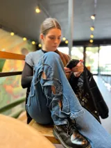 Pantalón de jean azul de tiro medio con diseño trenzado lateral.