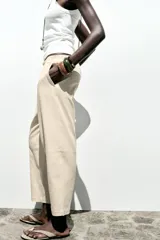 Pantalón bombacho color beige de lino, con cintura elástica, bolsillos frontales y bolsillos de parche en la espalda.
