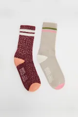 Pack de dos pares de medias Levi's de caña media. Un par color borgoña con lunares blancos y dos rayas blancas en la parte superior. El otro par color beige con rayas rosa y verde en la parte superior.