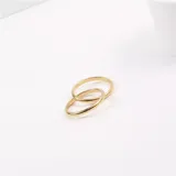 Set de dos anillos dorados de acero quirúrgico, entrelazados.