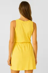 Vestido amarillo de algodón, sin mangas, al cuerpo, con elástico en la cintura y cuello redondo.