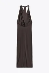 Vestido largo marrón oscuro con cuello halter y escote fluido. Tiene hombros descubiertos, detalle de pliegues laterales y forro interior a tono. Cierre lateral con cremallera oculta y en espalda con botones.