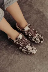Zapatillas bajas de cuero color marrón con suela de goma color caramelo y cordones marrones.