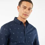 Camisa azul marino de corte recto y manga corta, con estampado de palmeras blancas.