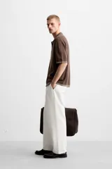 Camisa marrón de punto con viscosa, corte relaxed fit, cuello solapa, manga corta y cierre frontal con botones.