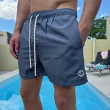 Short de baño azul con cintura elástica y cordón ajustable.