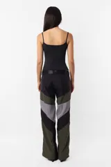 Pantalón negro de corte recto y tiro medio, con recortes en las piernas con detalle de vivo. Cintura con presillas y cinto correa con broche plástico incluido.