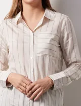 Camisa a rayas verticales color beige y gris, marca Alex & Jordan. Tiene cuello con solapa, abertura central con botones y bolsillo aplicado en el pecho.