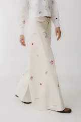 Pantalón de jean color crudo, corte wide leg, con bordados de cartas, dados y fichas de casino.