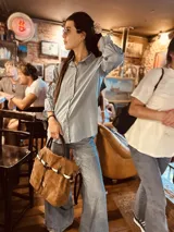 Bolso marrón de cuero gamuzado con correa bandolera de cuero marrón y detalle de cuero con estampado animal print.