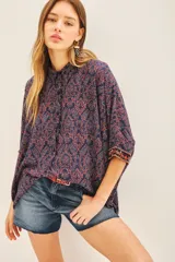 Camisa de algodón con estampado floral en tonos azul y rojo, corte amplio y mangas 3/4 con detalle bordado en los puños.