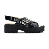 Sandalias con plataforma baja color beige, con capellada símil charol y tachas decorativas.