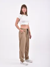 Pantalón de vestir color negro, de corte recto, con bolsillos laterales y traseros. Se ajusta a la cintura con cinturón de cuero marrón.