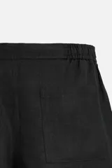 Bermuda regular fit negra confeccionada en tejido de lino. Cintura elástica ajustable con cordón y pliegues frontales. Bolsillos frontales y detalle de bolsillos traseros de plastrón.