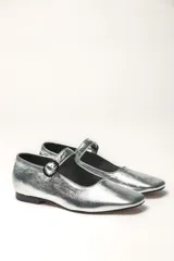 Zapato estilo Mary Jane color marrón, de cuero, con punta redondeada y tira sobre el empeine con hebilla.