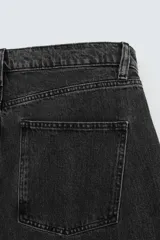 Pantalón de jean negro de corte amplio, estilo balloon fit, con cinco bolsillos y cierre frontal con botones.