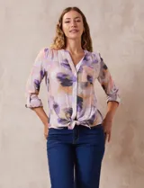 Blusa estampada con cuello a la base, escote en V y botones. Delantera con bolsillo aplicado. Largo de manga regulable con presilla y botón. Terminación anudada opcional.