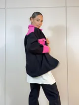 Sobre camisa negra con canesú, bolsillo y puños en color fucsia.