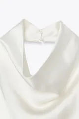 Top color champagne de cuello halter con espalda descubierta y cierre trasero con botones ocultos.