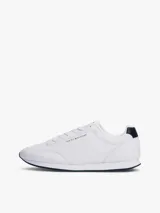 Zapatillas Tommy Hilfiger blancas de estilo running, con suela dentada fina y logo de la marca en el lateral.