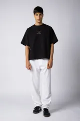 Pantalón de lino color beige, de corte recto y holgado, con cintura elastizada y cordón ajustable. Presenta bolsillos laterales amplios.