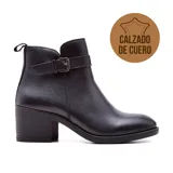 Bota corta de cuero negro con taco bajo y hebilla decorativa.