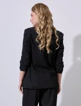 Blazer blanco de lino con cuello con solapa, bolsillos sastre y mangas fruncidas.