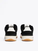 Zapatillas urbanas Tommy Jeans de corte bajo, color negro, confeccionadas en ante con interior de poliéster, entresuela texturizada color crema y suela de goma color caramelo. Presentan logo de la marca en el lateral y en la lengüeta.