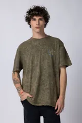 Remera de hombre color gris oscuro con efecto gastado (snow wash), corte semi-oversize y un pequeño estampado circular en el pecho que simula una obra de arte.