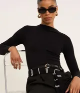 Blusa negra de mangas largas, confeccionada en viscosa sostenible, con cuello redondo y sisas raglán.