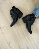 Botines negros de cuero con textura de piel de serpiente, punta fina, cierre lateral y apliques de tachas plateadas.