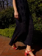 Vestido midi de tejido de punto con lurex color borgoña, corte recto, sin mangas y con tajos laterales.