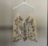 Top de fiesta negro con lentejuelas rosas y plateadas, escote en V y tirantes finos.