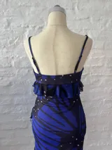 Vestido corto con estampado de mariposas azules y negras, escote en V con volantes y tirantes finos.