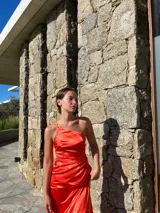 Vestido midi de satén azul eléctrico, con breteles finos, corte al bies y falda irregular con volados.