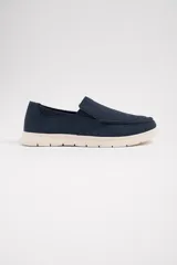 Mocasines náuticos azul marino con suela blanca.