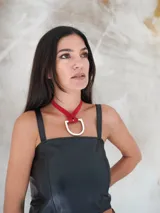 Collar con tira de cuero color suela y dije metálico dorado en forma de estribo.