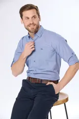 Camisa de manga larga celeste con estampado de cuadros pequeños, corte slim fit, cuello clásico y bolsillo en el pecho. Confeccionada en algodón.