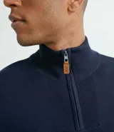 Suéter azul marino de tejido de punto liso, con cuello alto y cremallera corta.