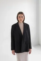 Blazer gris de corte clásico con solapas de muesca, cierre frontal con dos botones y bolsillos laterales con solapa.