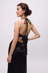 Vestido midi amarillo de satén con escote halter, trenzas en cuello y cintura, cut-outs laterales y falda recta.