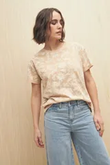 Remera blanca de manga corta con estampado floral en tonos beige.